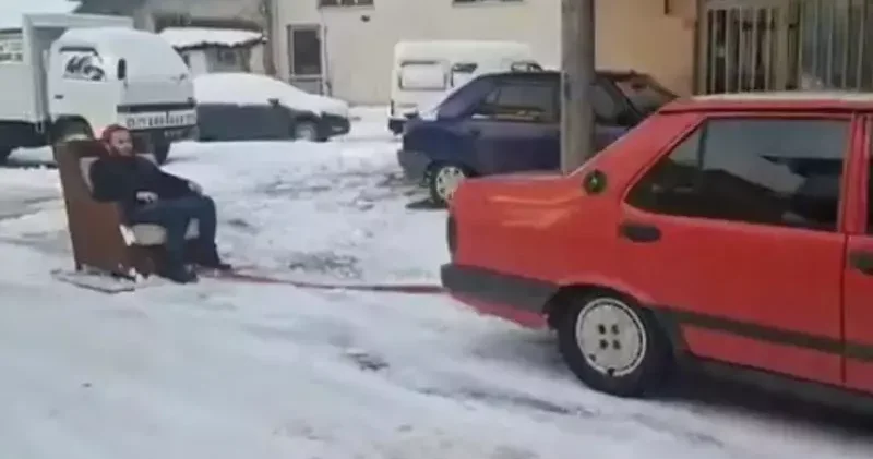 Otomobile bağladığı koltukla kayak yaptı