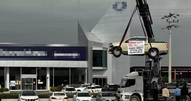 Aldığı sıfır kamyoneti, hatalı çıktığını öne sürüp, bayinin önünde vinçle kaldırarak sergiledi