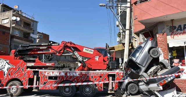 Rampada geri kayan vinç, 2 otomobili ezip, aydınlatma direği ile iş yerine çarptı İzmir Haberleri