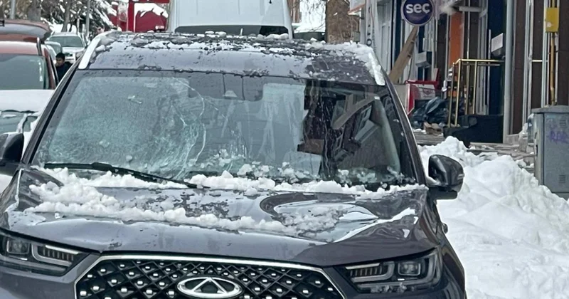 Park halindeki otomobilin üzerine kar ve buz kütlesi düştü