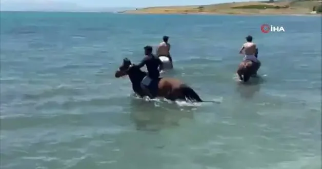 Sıcaktan bunalan gençler atlarıyla Van Gölü nde serinledi