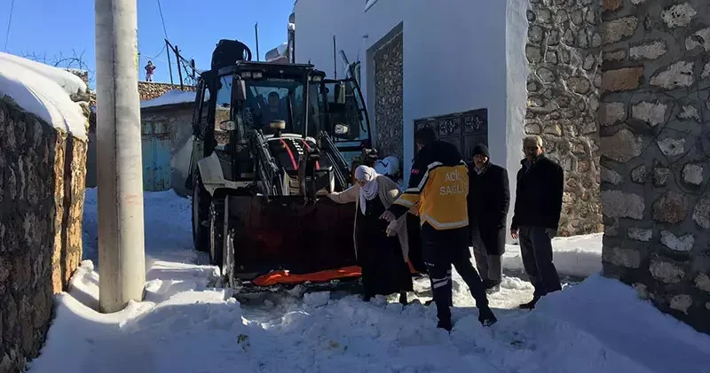 Kardan yolu kapanan mahallede hastalanan kadın, kepçeyle ambulansa taşındı