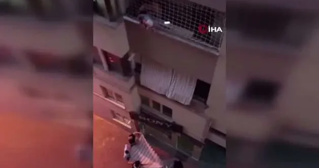 Balkon filesinde asılı kalan çocuğunu düşmesin diye dakikalarca tuttu