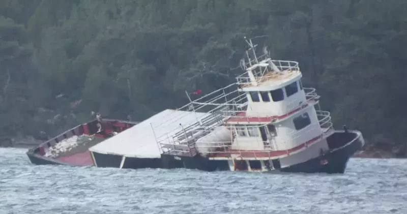 Balıkesir de kuvvetli lodos nedeniyle sürüklenen feribot karaya oturup, yan yattı