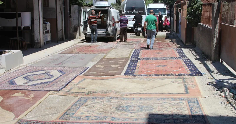 Asfaltlanmayan sokağın tozundan rahatsız olan mahalleli yola halı serdi