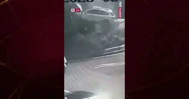 Çin de akılalmaz kaza: Kaldırıma çarpan otomobil ağaçla trafo arasında asılı kaldı!