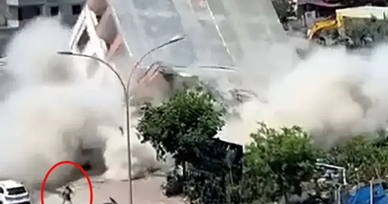 Apartmanın yıkımı sırasında, kaldırımdaki kadın enkaz altında kalmaktan son anda kurtuldu