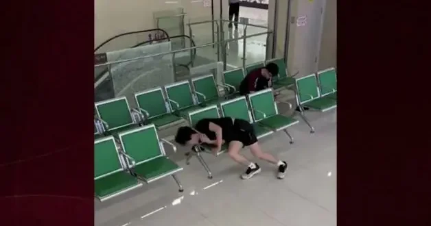 Çin de bekleme salonunda kafası koltuğun kenarına sıkışan gencin zor anları