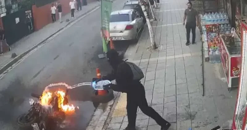 Küçükçekmece de yanan motosiklete marketin önündeki su bidonlarıyla müdahale kamerada
