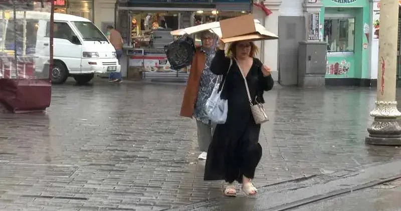 Taksim’de yağmura yakalananlar çanta ve kartonla korunmaya çalıştı