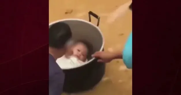 Çin de sel sularında mahsur kalan baba bebeğini tencereyle kurtardı