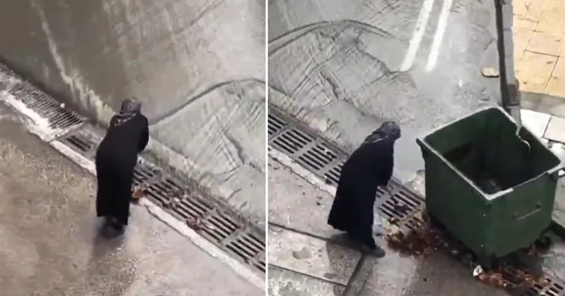 Belediye ekiplerini beklemeyen yaşlı kadın mazgalları bastonuyla temizledi