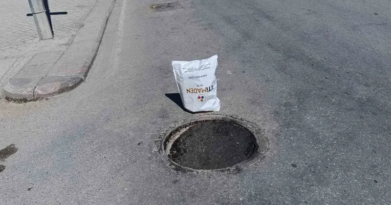Çöken rögar kapağını gören vatandaş poşetle önlem aldı