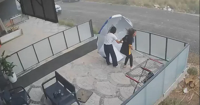 Şiddetli rüzgarın şemsiyeyle imtihanı kamerada