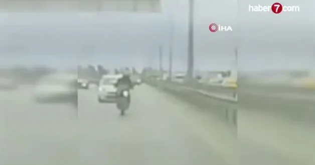 Köprüden sarkan reklam afişi motosikletliyi yola savurdu