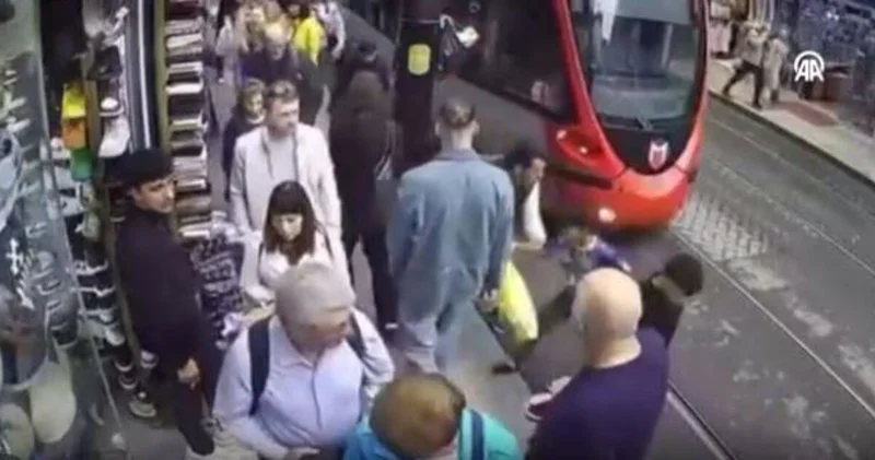 İstanbul da bir kişinin tramvay yolundaki çocuğu olası kazadan kurtarması kamerada Son dakika haberleri