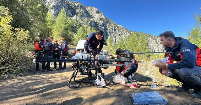 Yazılı Kanyon da mahsur kalanlar için dev milli dron ile erzak gönderiliyor 25 kilo ağırlık taşıyabilen yerli ve milli drona, içinde gıda ürünlerinin olduğu poşetler bağlanıp havalandı Isparta Haberleri Habertürk Yerel Haberler