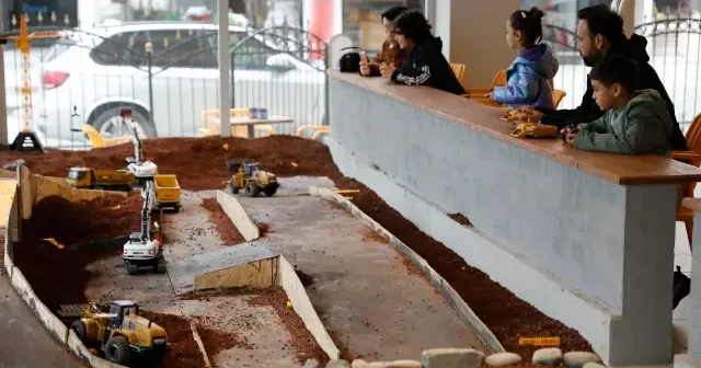 Bu kafenin müşterileri minyatür inşaat sahasında iş makineleriyle oynuyor VİDEO İZLE