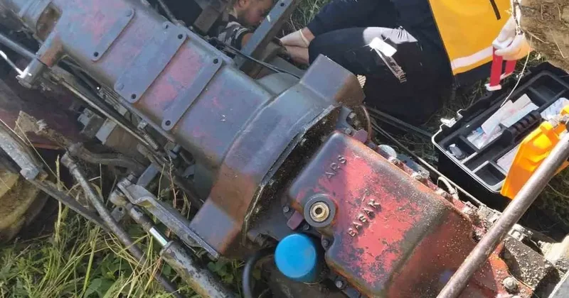 Devrilen traktörün altında kalan sürücü yaralandı