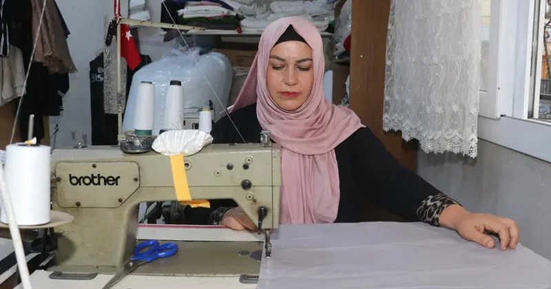 Kadın muhtar mahallelinin hem derdini dinliyor hem terziliğini yapıyor