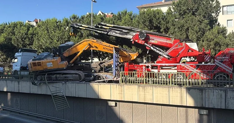 Tırın üzerinden düşen ekskavatör korkuluklarda asılı kaldı
