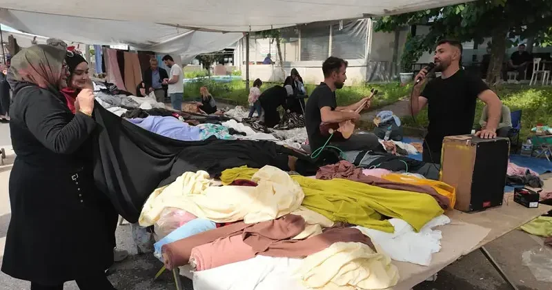 Semt pazarında kendi bestelerini seslendirip satış yapıyor