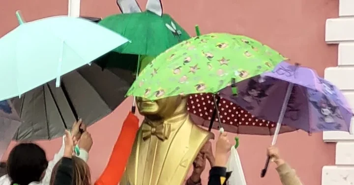 Adana da ilkokul öğrencileri yağmur altında Atatürk büstünü şemsiyeyle korudu