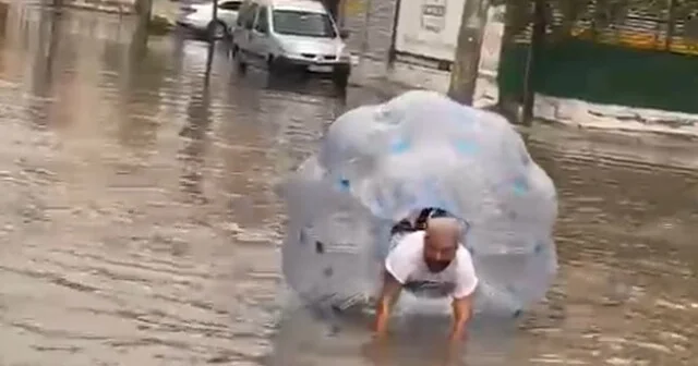 Sağanakta suyla dolan caddede içine girdiği büyük şeffaf balonla ilerledi Mersin Haberleri Habertürk Yerel Haberler
