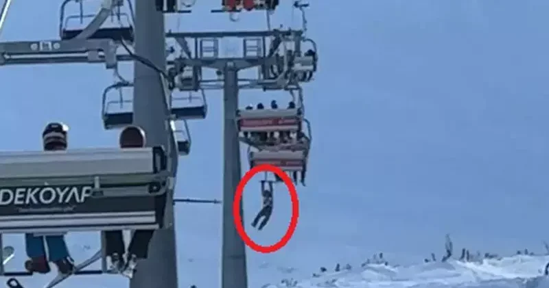 Düşen snowboardını almak için atlamaya çalıştığı telesiyejde asılı kaldı; o anlar kamerada